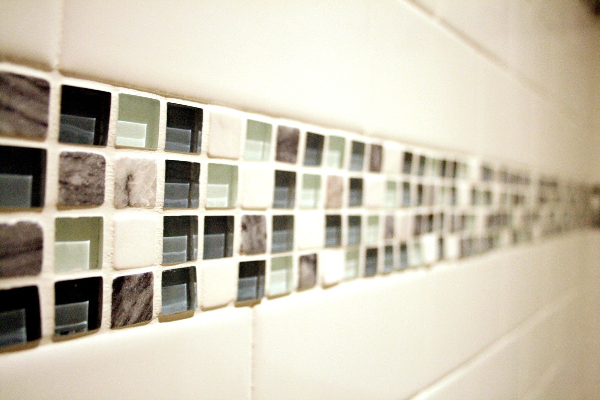 Close-up of mosaic glass tile accent in a custom shower remodel by At Design Remodel in Mashpee