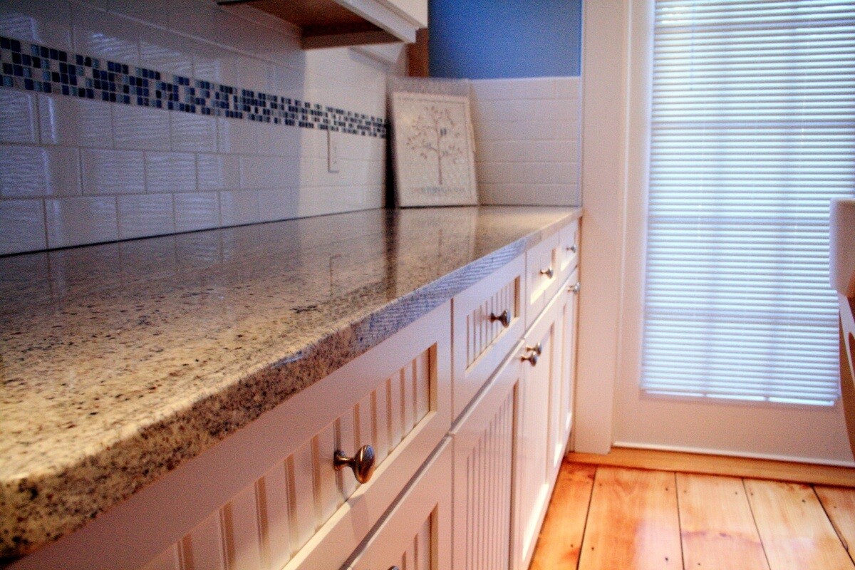 Custom granite countertops and cabinetry in a Mashpee kitchen remodel by At Design Remodel