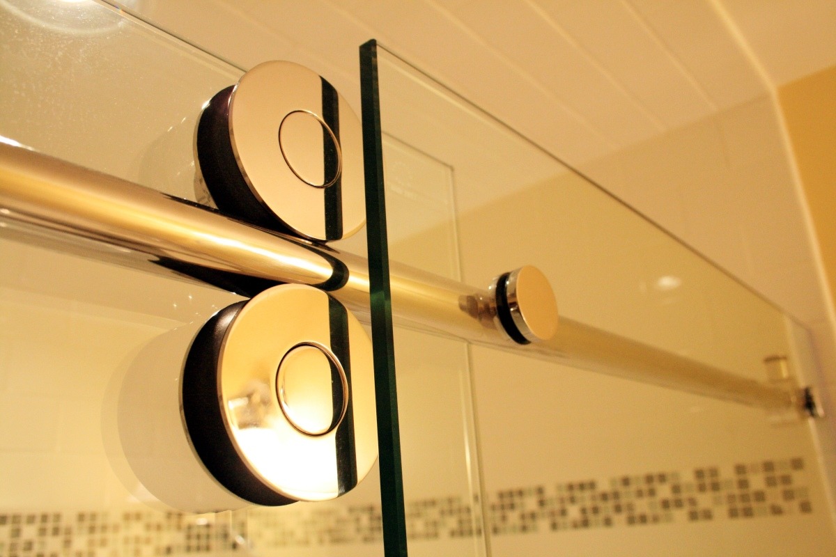 Modern glass shower door rollers in a bathroom renovation by At Design Remodel, Mashpee