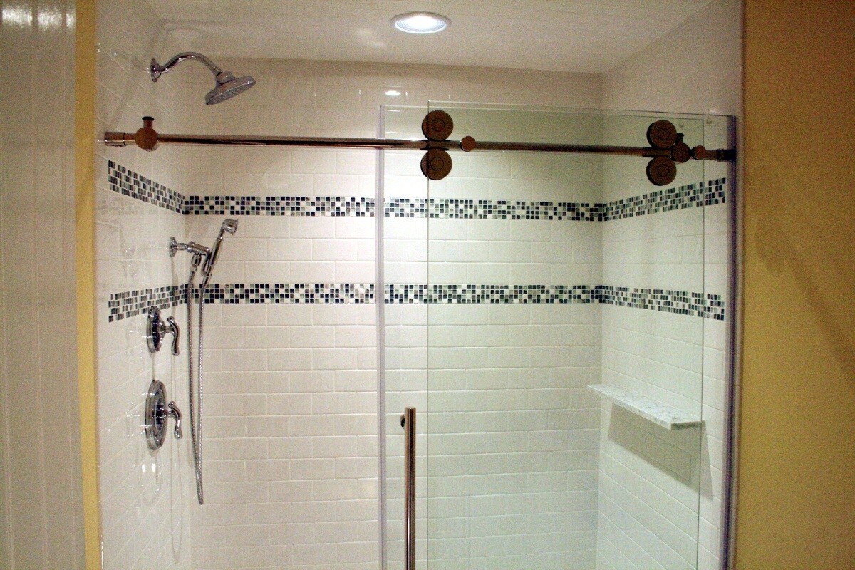 Modern glass-enclosed shower with mosaic tile design in a Maushop remodel, Mashpee