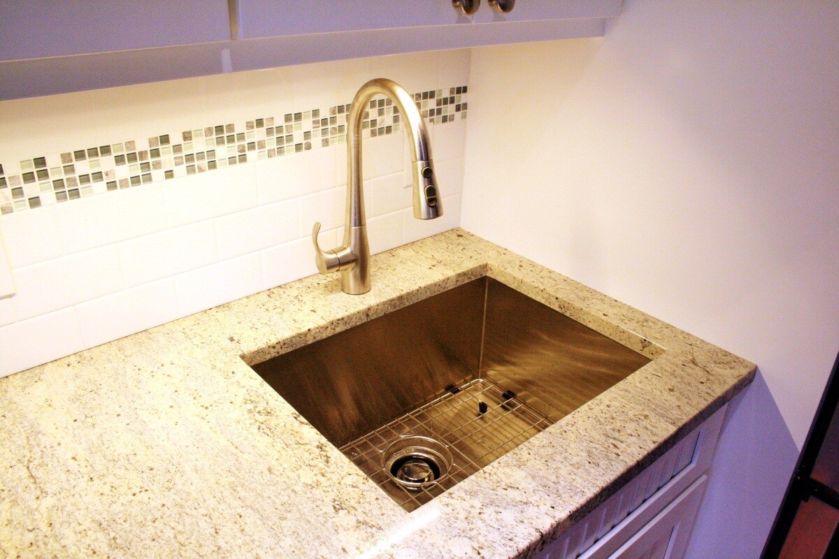 Undermount stainless steel sink with granite countertops in a Mashpee kitchen upgrade by At Design Remodel