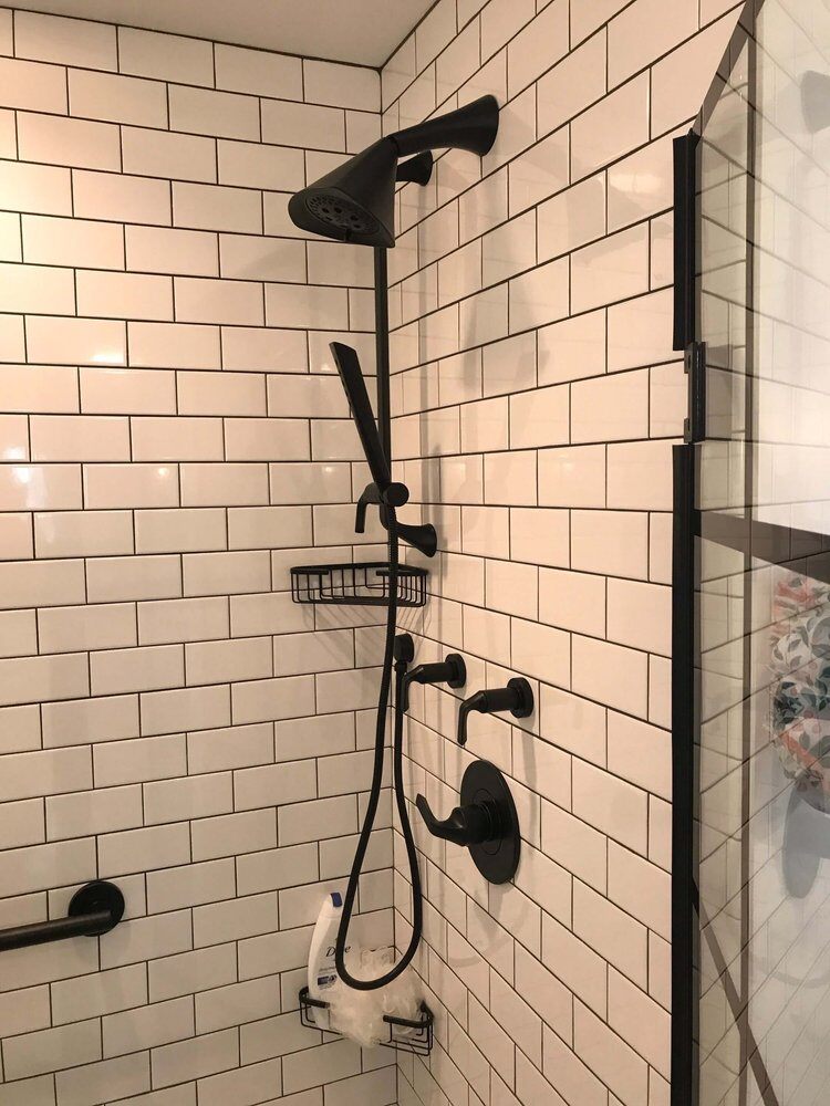 Modern shower with black fixtures and white tile in Bay Road Bath remodel by At Design Remodel, North Falmouth, Mashpee