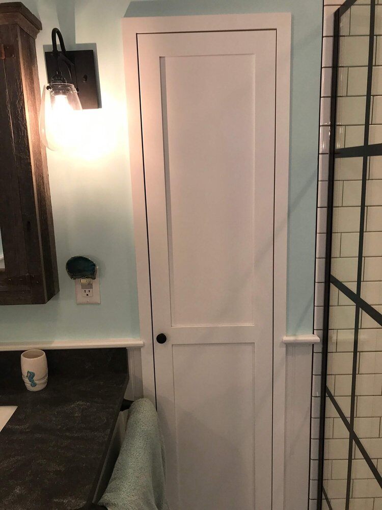 White cabinet door beside vanity in remodeled bathroom, Bay Road Bath project in North Falmouth by At Design Remodel, Mashpee