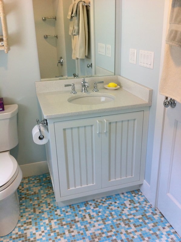 Close-up of a pebble mosaic floor in a bathroom remodeled by At Design Remodel in Cataumet