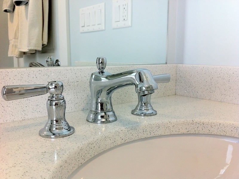 Close-up of chrome faucet and countertop in a bathroom renovation project by At Design Remodel, Cataumet, MA