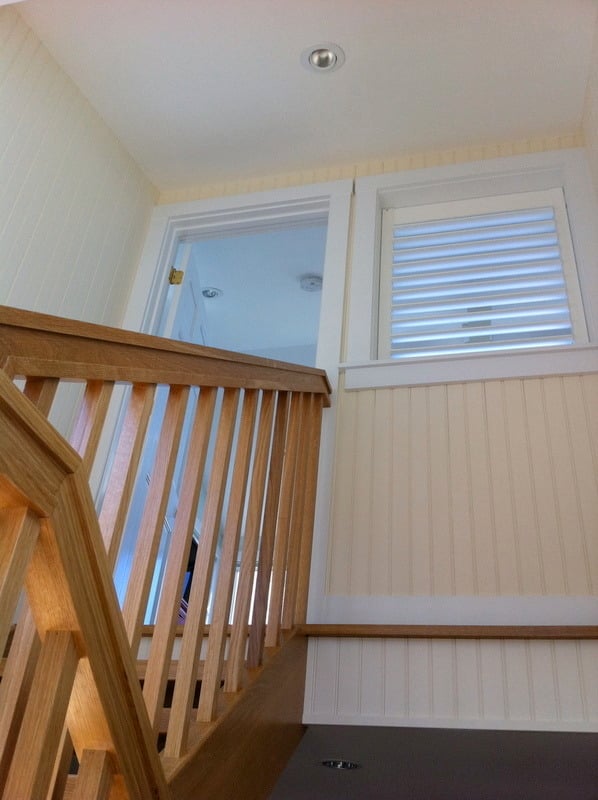 Close-up of wooden staircase with detailed railing in a Cataumet custom home