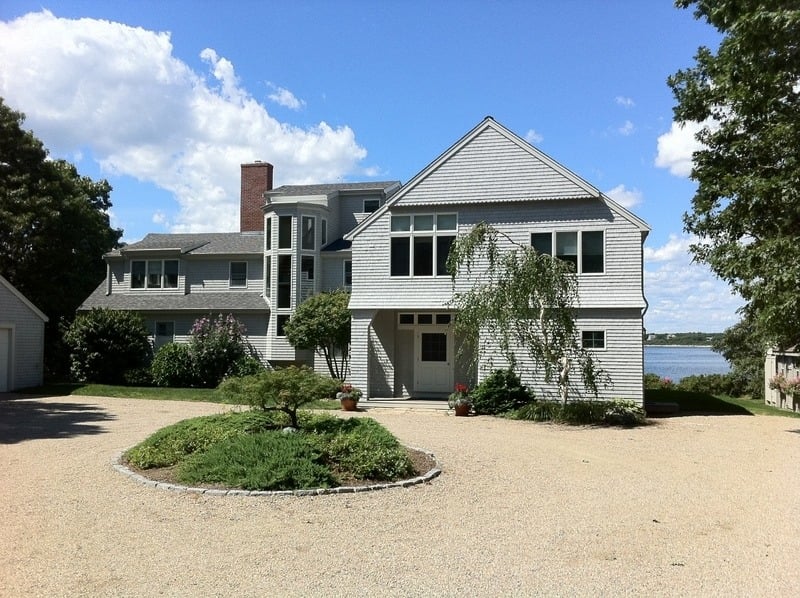 Exterior of a custom home in Cataumet featuring a circular driveway and a landscaped front yard