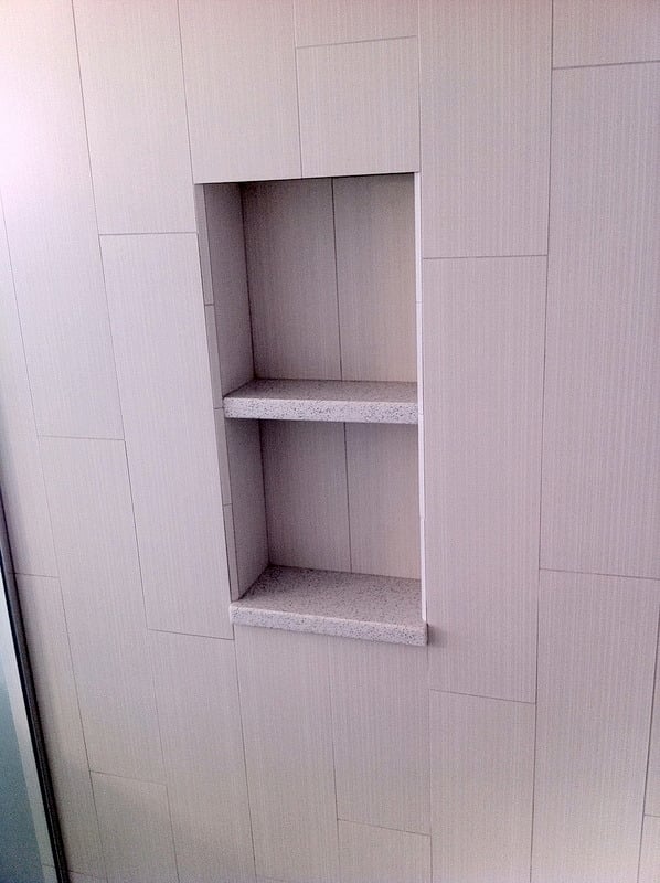 Recessed shower shelf in a tiled shower area from a bathroom remodel by At Design Remodel in Cataumet