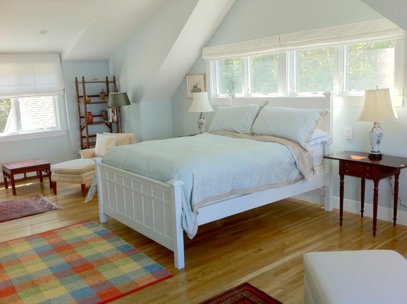 Renovated bedroom with bright natural light and a cozy sitting area in a Cataumet custom home