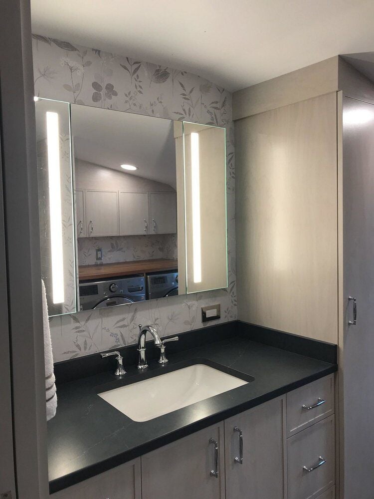 Bathroom vanity with illuminated mirror in Centerville remodel by At Design Remodel in Mashpee