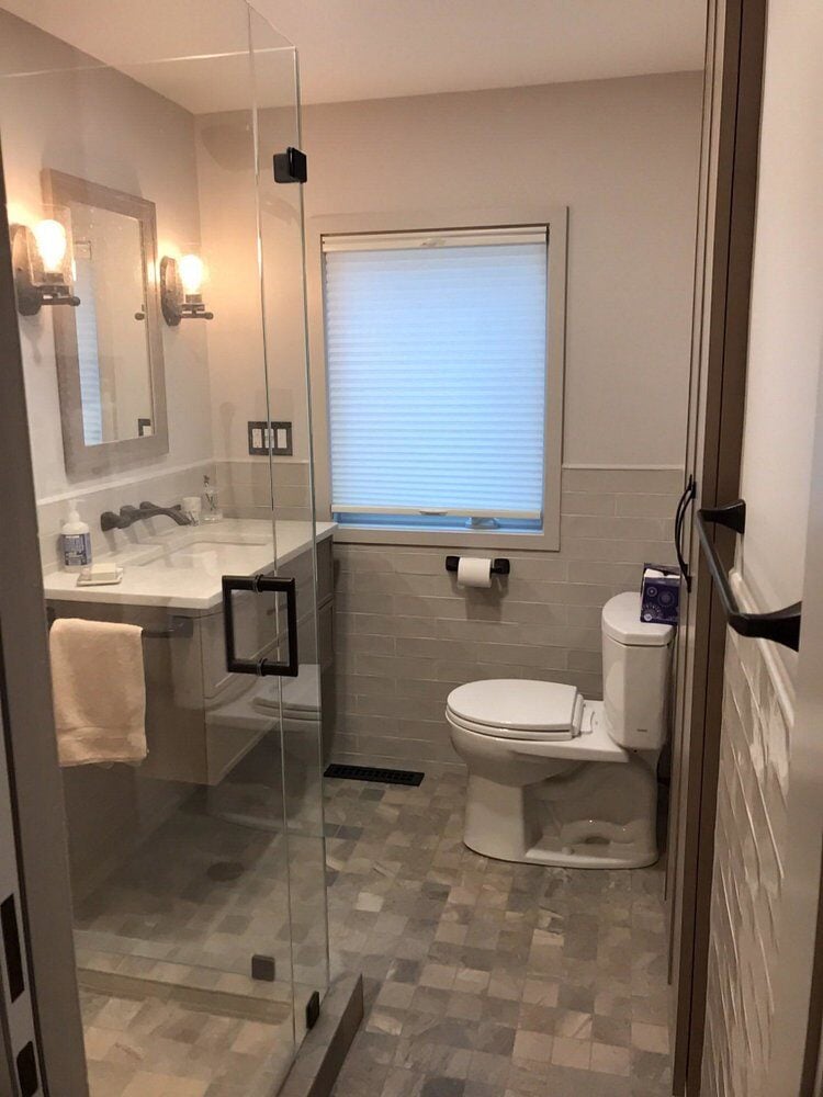 Centerville bathroom remodel featuring a glass shower and modern fixtures by At Design Remodel, Mashpee