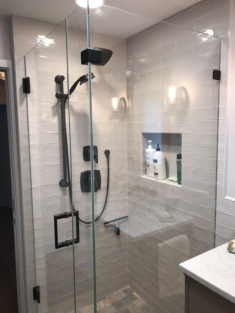 Glass-enclosed shower with modern fixtures in Centerville bathroom remodel by At Design Remodel, Mashpee