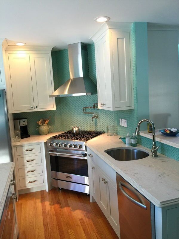 Custom kitchen remodel in Mashpee featuring a seagreen backsplash and white cabinetry by At Design Remodel