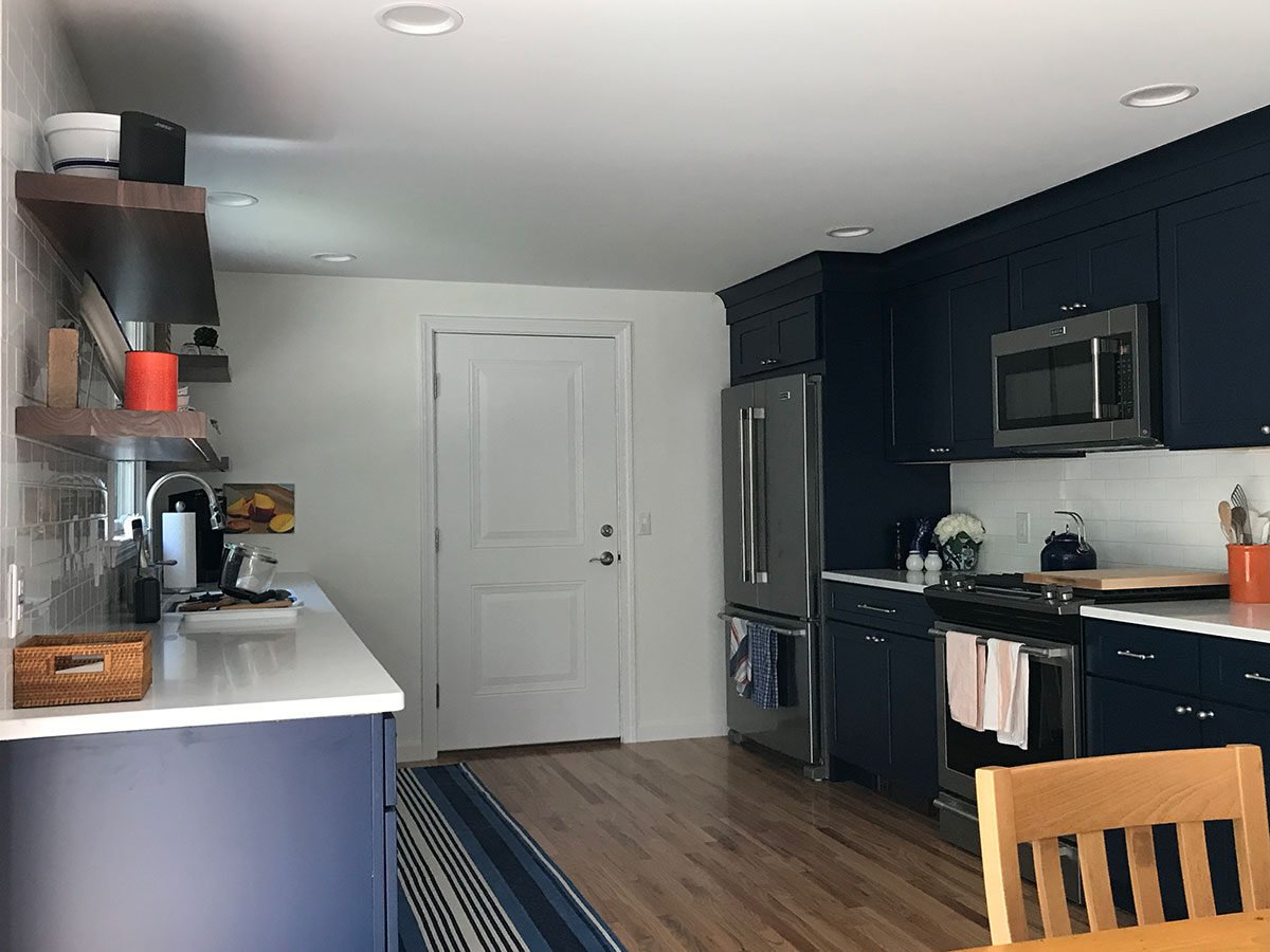 Dennis kitchen remodel with sleek navy cabinets and modern appliances by At Design Remodel, Mashpee