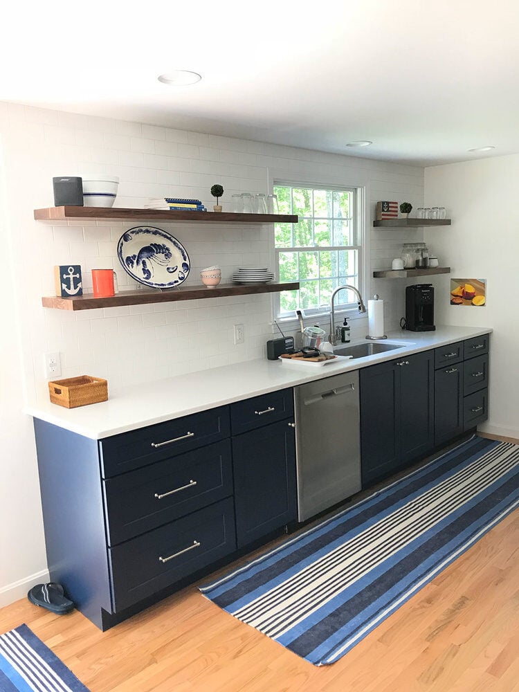 Sleek kitchen with open shelving and navy lower cabinets, At Design Remodel project in Dennis, Mashpee