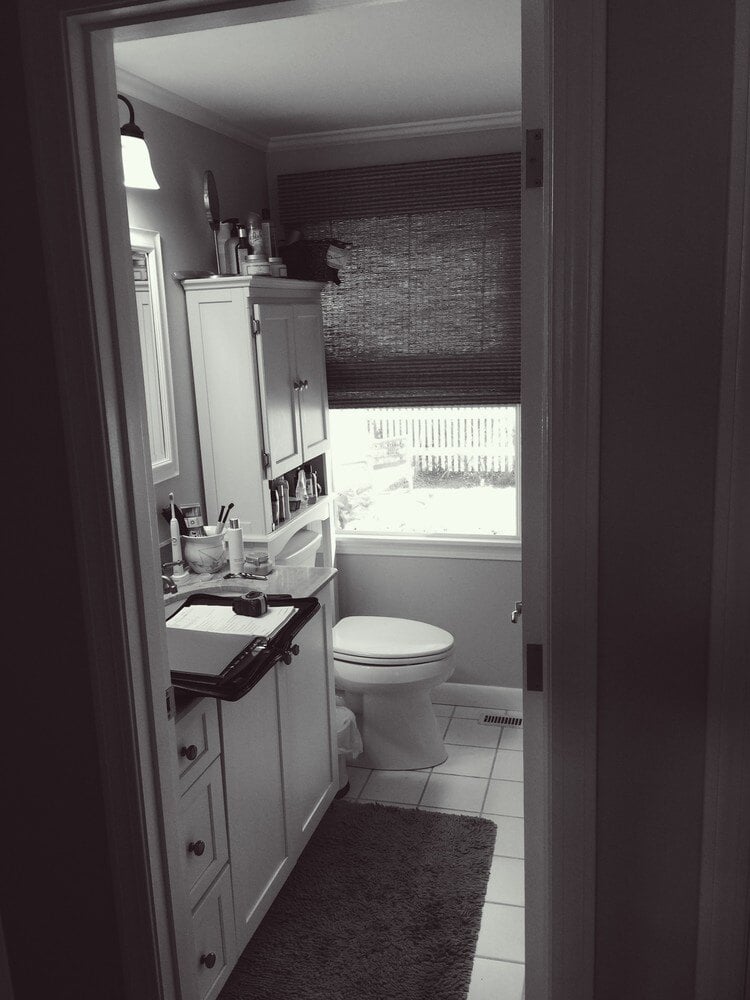 Compact bathroom with natural lighting and white vanity in a home renovation by At Design Remodel in Mashpee