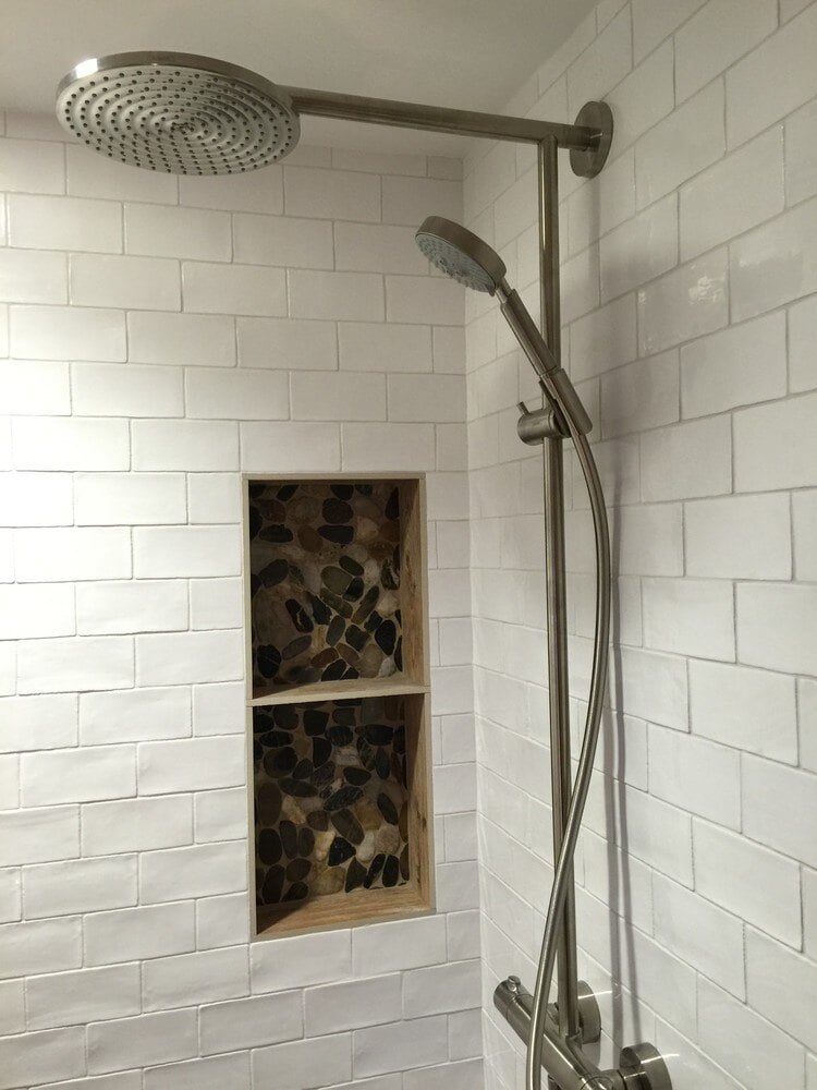 Rainfall showerhead with subway tile backdrop in a Falmouth bathroom remodel by At Design Remodel in Mashpee