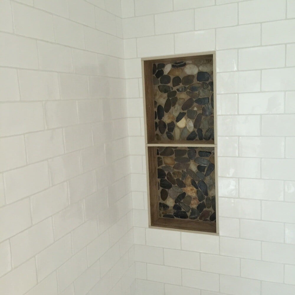 Subway-tiled shower with natural stone accent shelves in a contemporary bathroom remodel by At Design Remodel in Mashpee