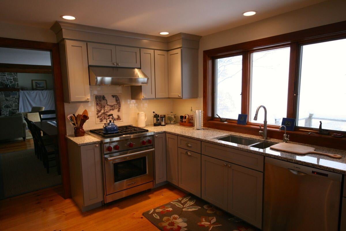 Bright kitchen with stainless steel appliances and large window in a Falmouth renovation