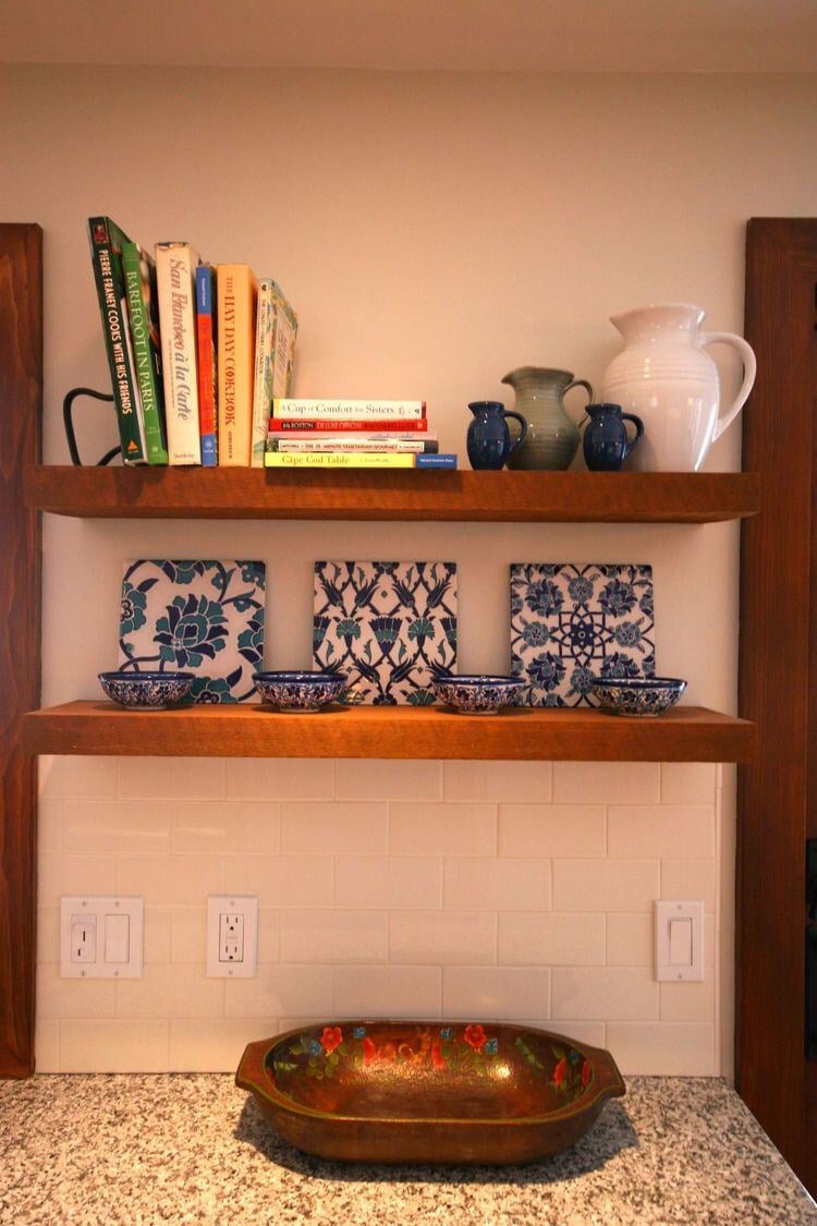 Decorated kitchen shelves with books and ceramics in a remodeled Falmouth home