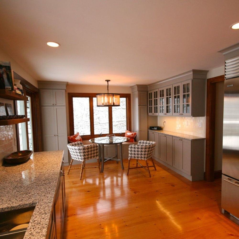 Kitchen dining nook with houndstooth chairs and natural wood flooring in Falmouth