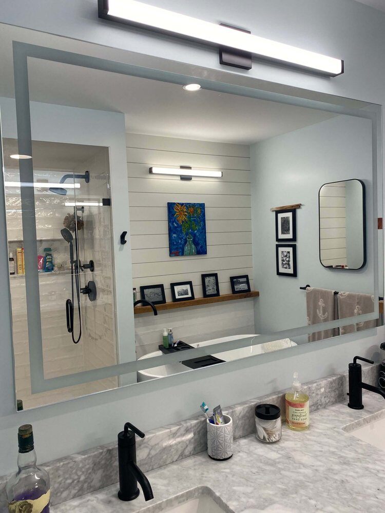 Dual sinks and large mirror in a modern master bathroom remodel by At Design Remodel, Dennis, MA