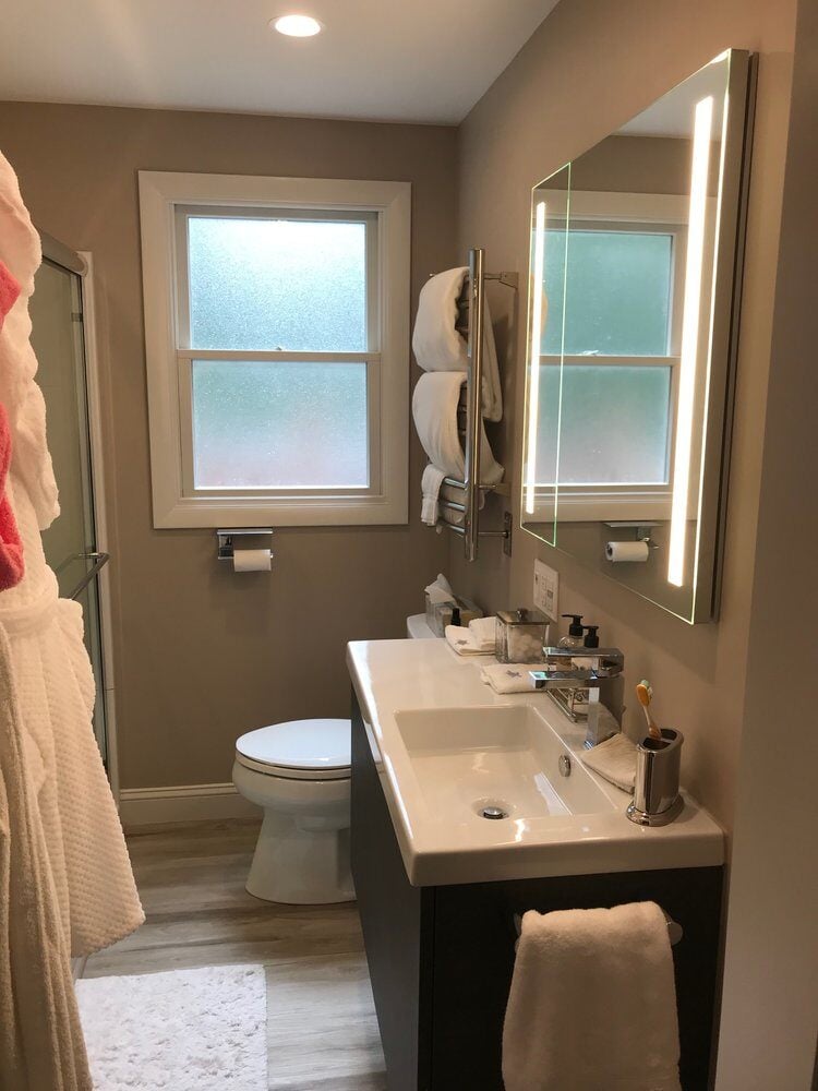 Renovated bathroom with elegant vanity and mirror lighting by At Design Remodel on Treasure Lane, Mashpee