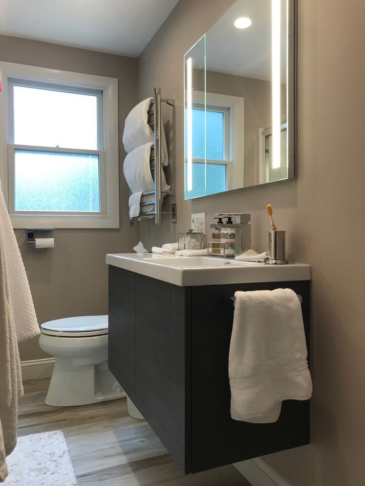 Updated bathroom with sleek vanity and window lighting by At Design Remodel, Mashpee, Treasure Lane