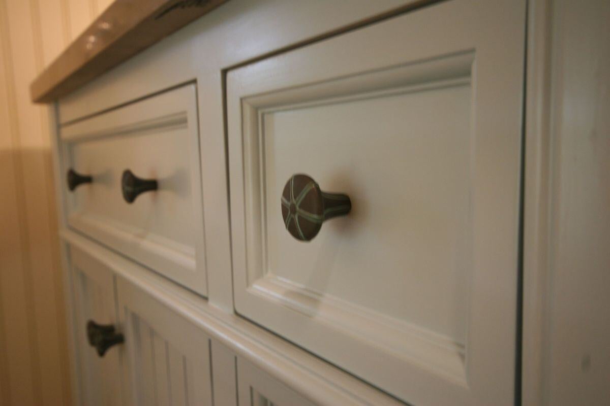 Detailed view of vanity cabinet handles in remodeled Mashpee bathroom