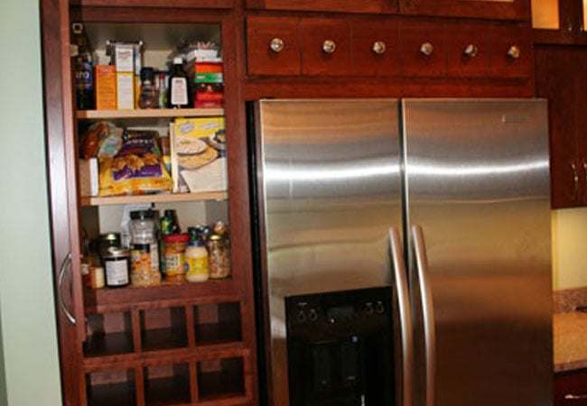 Custom kitchen remodel in Mashpee by At Design Remodel showcasing a stainless steel fridge and pantry storage