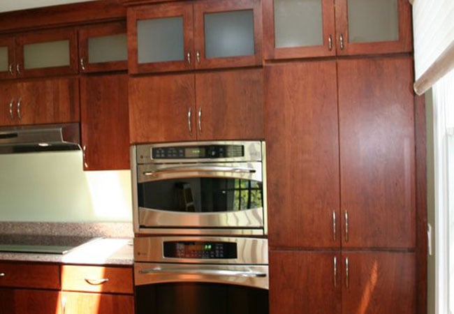 Double oven installation in a Mashpee kitchen remodel by At Design Remodel, featuring dark wood cabinetry