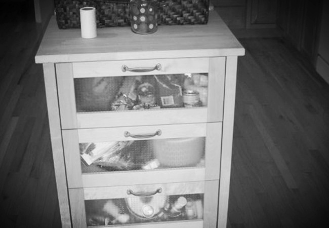 Glass-front kitchen storage cart in a custom home remodel by At Design Remodel in Mashpee