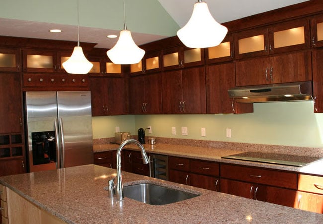 Mashpee kitchen remodel by At Design Remodel with granite countertops and pendant lights above an island