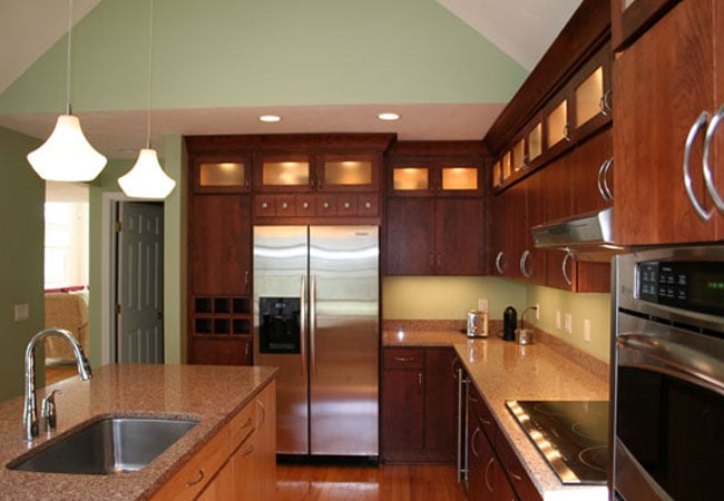 Open concept kitchen with granite countertops in a Mashpee home remodel by At Design Remodel