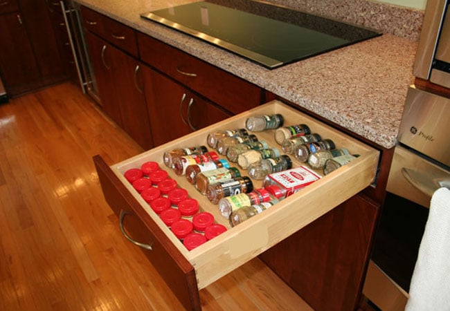 Spice drawer with organized jars in a Mashpee kitchen remodel by At Design Remodel