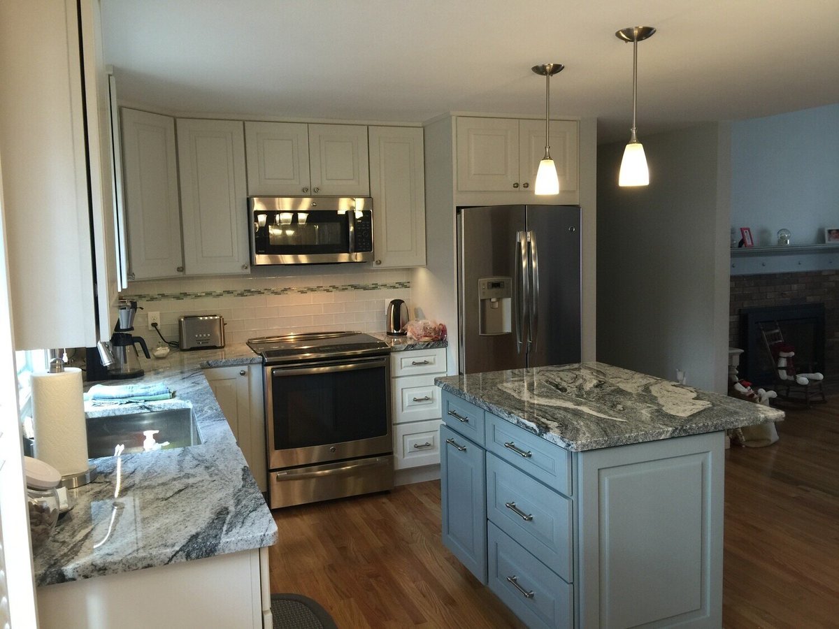 After photo of Mashpee kitchen renovation featuring white cabinets, granite countertops, and stainless steel appliances by At Design Remodel