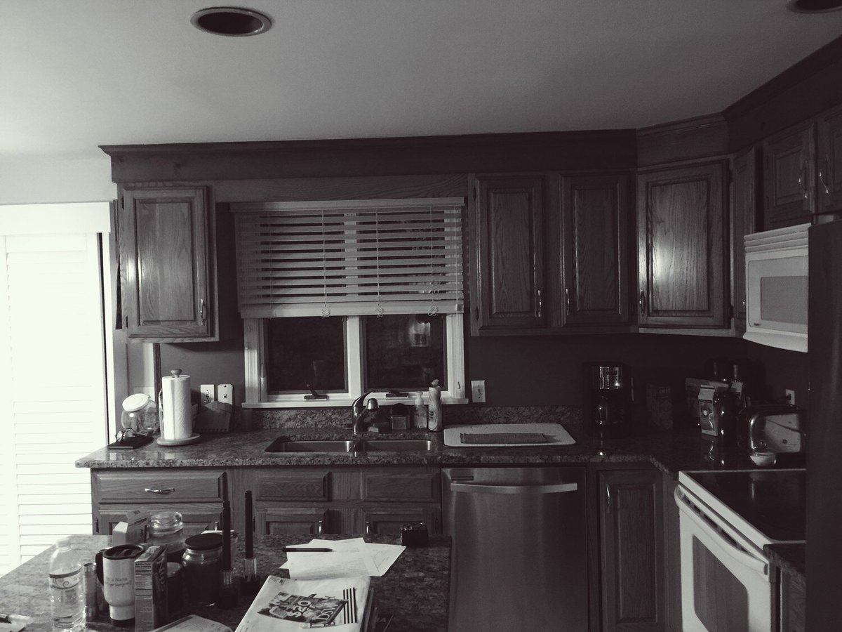 View of Mashpee kitchen before remodeling, showcasing oak cabinets and stainless steel dishwasher, part of At Design Remodel project