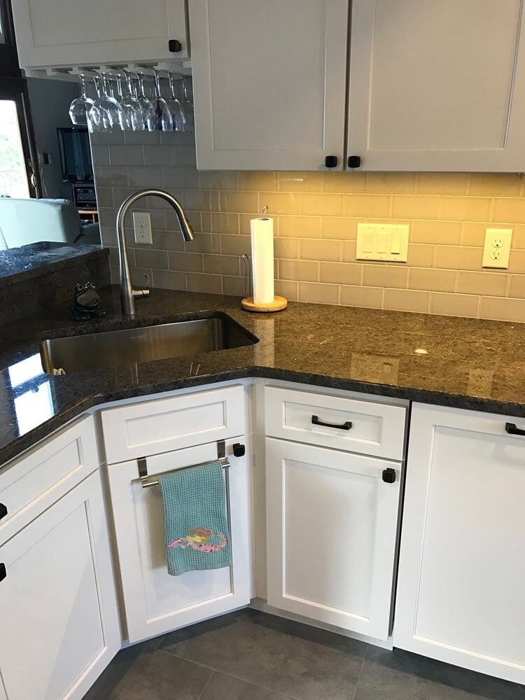 Granite kitchen countertop with stainless steel sink and subway tile backsplash by At Design Remodel in Mashpee