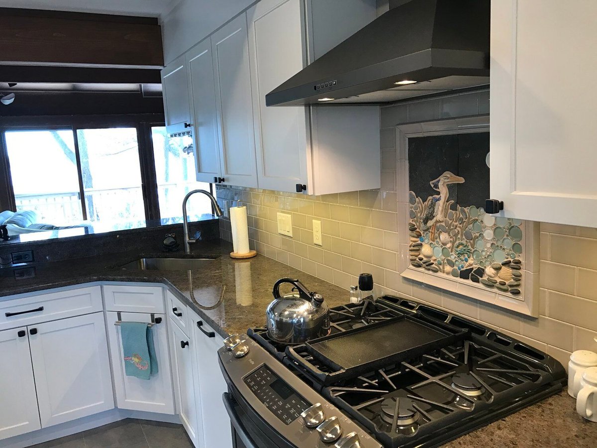 Modern kitchen remodel featuring granite counters and artistic backsplash in Mashpee by At Design Remodel