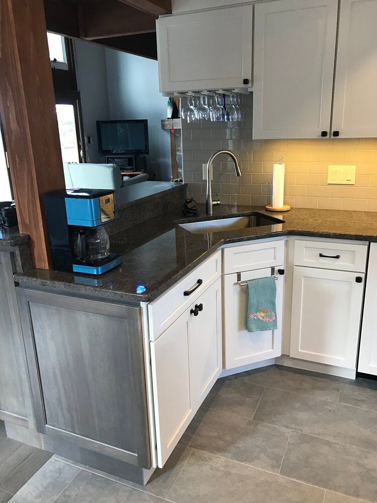 Remodeled kitchen with granite countertops and stainless steel sink by At Design Remodel in Mashpee