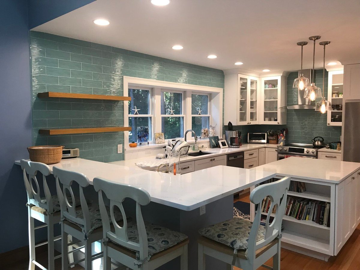 Custom kitchen renovation in Mashpee featuring a white island and teal backsplash by At Design Remodel