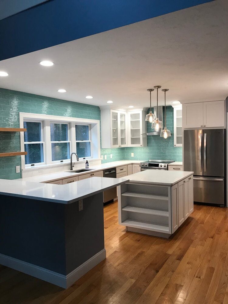 Open kitchen with teal backsplash and white countertops remodeled by At Design Remodel in Mashpee