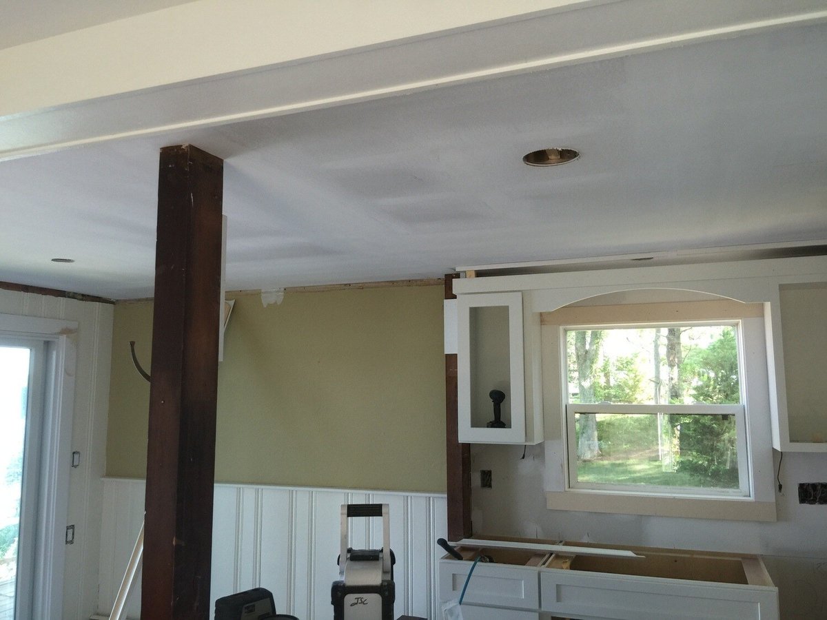 Ceiling renovation with exposed beams in a Mashpee lakefront cottage kitchen by At Design Remodel