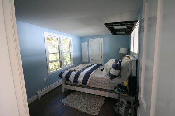 Freshly remodeled bedroom featuring blue walls and large windows in a Mashpee custom home