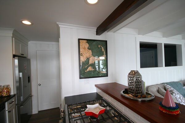 Kitchen renovation showing rustic wood beams and modern appliances, part of Mashpee Lake Cottage makeover by At Design Remodel
