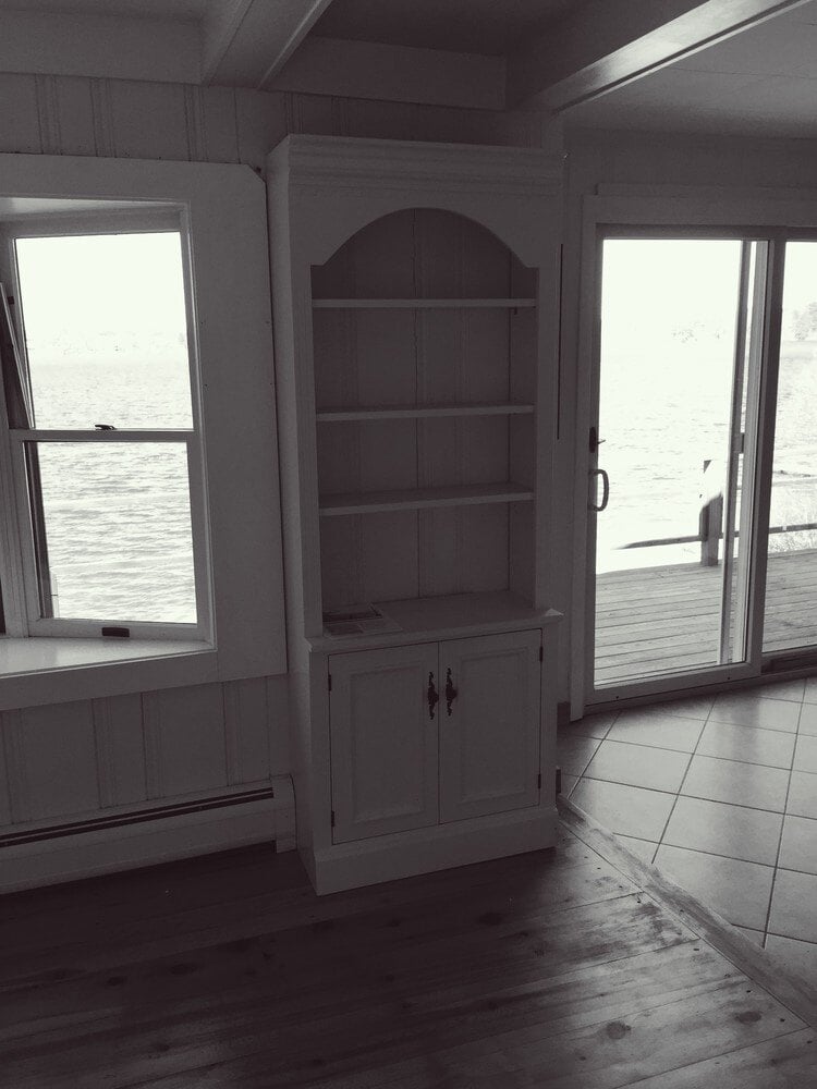 Lakefront view with built-in shelving in a Mashpee cottage, remodeled by At Design Remodel