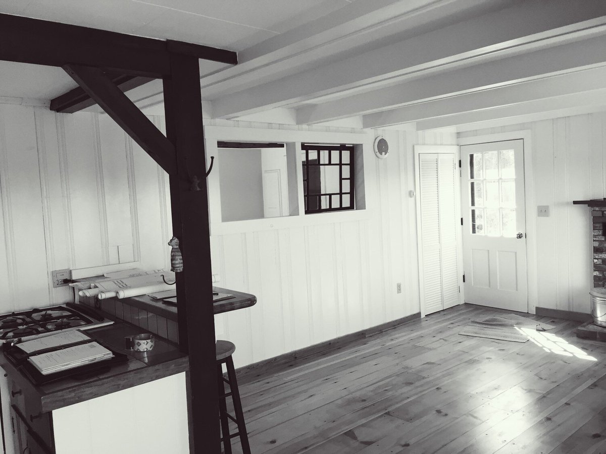 Newly remodeled kitchen with wooden beams and white walls, part of a Mashpee Lake Cottage makeover by At Design Remodel