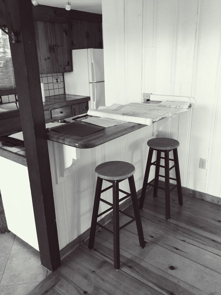 Rustic kitchen countertop with barstools in a Mashpee cottage renovation by At Design Remodel