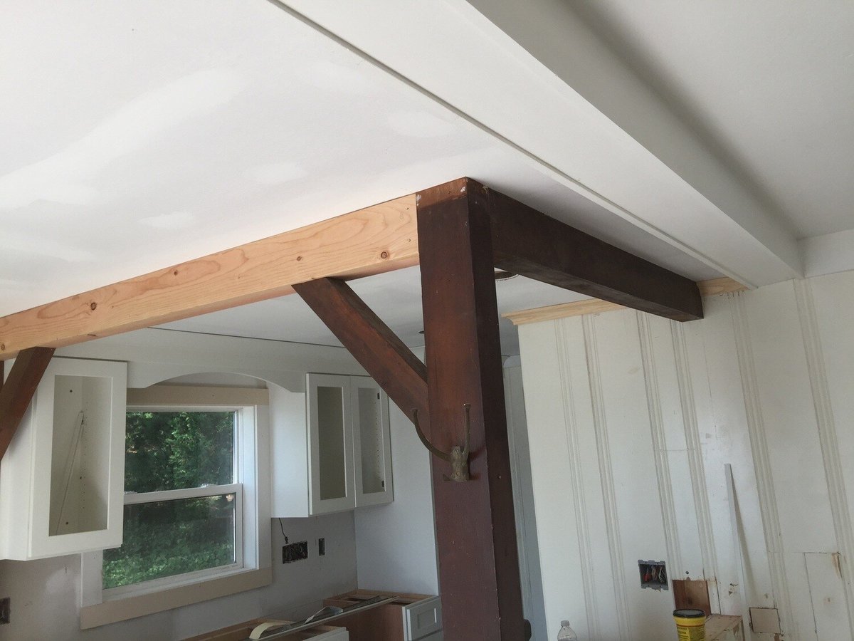 Wooden beam and window frame installed in the kitchen area of a Mashpee cottage remodel by At Design Remodel