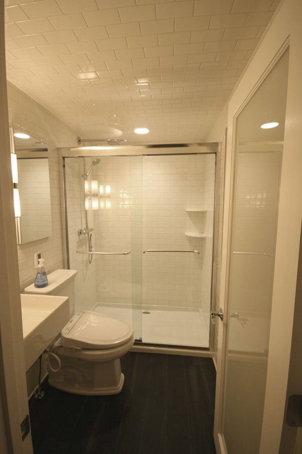 White subway-tiled shower with glass doors in a contemporary bathroom remodel by At Design Remodel in Mashpee